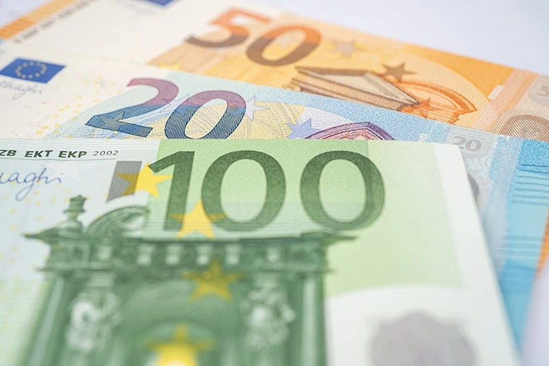 Mehrere Euro-Banknoten in 100, 50 und 20 Euro liegen übereinander und zeigen die typischen Farben der Geldscheine im unscharfen Nahbereich.